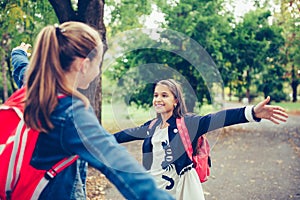 Two school friends hugging, meet in the park