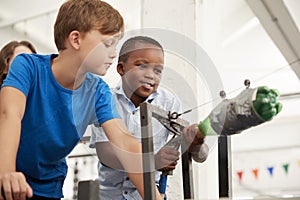 Two schoolboys using air pressure rocket at a science centre