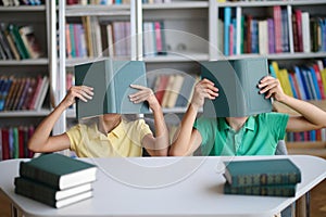 Two schoolchildren having fun at the library