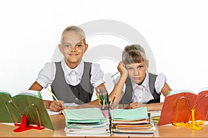 Two schoolgirls at a desk, one funny, the other upset