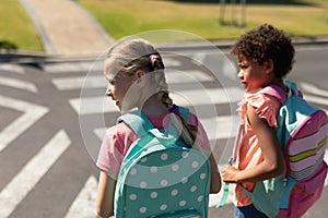 Two schoolgirls looking for traffic while waiting to cross the road