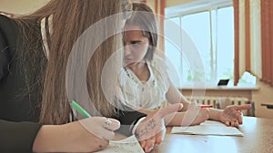 Two schoolgirls use cheat sheets on an important exam.