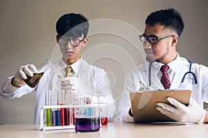 Two Scientist men test liquid substrance in lab