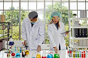 Two Scientists Conducting Research analyzing chemical experiments in Laboratory