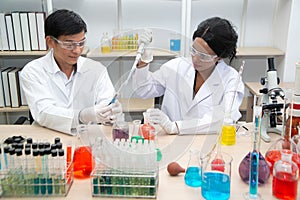 Two scientists are working in laboratory.Young female researcher and her senior supervisor are doing investigations on laboratory.