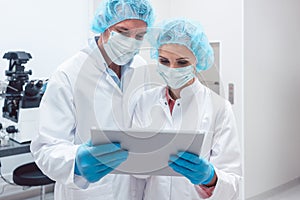 Two scientists working together in lab looking at data