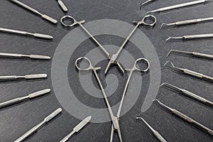 Two scissors lay in different dental instruments on background