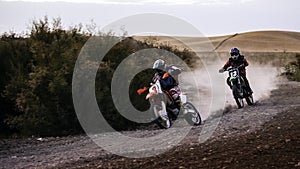 Two scrambler bikes racing on a dirt track
