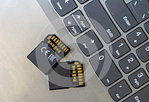Two sdxc card v60 are on the laptop near the keyboard