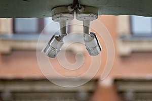 Two security cameras on the wall of a street yellow house. CCTV on wall