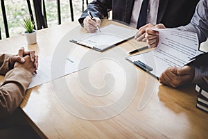 Two selection committee manager reading a resume during a job interview, Employer interviewing to ask young female job seeker for photo