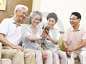 Two senior asian couples taking a selfie