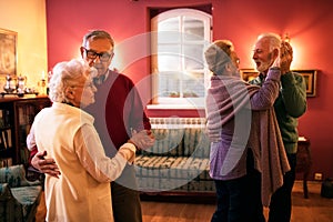 Two senior couple dancing and enjoy together at home