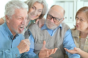 two senior couples singing karaoke