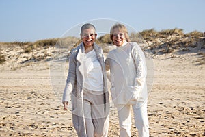 Two senior female friends having fun at seashore