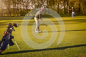 Two senior golfer playing golf at dusk.