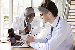 Two senior healthcare workers in consultation using laptop