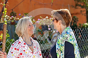 Two senior ladies chatting in the garden