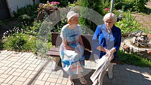 Two senior ladies sitting on a bench at park