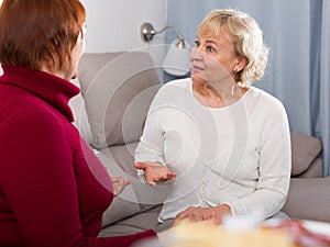 Two senior ladies talking on sofa