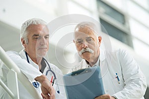 two senior male doctors conferring