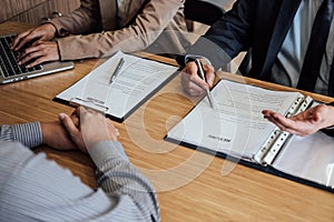 Two senior manager reading a resume during a job interview, Employer interviewing to ask young male job seeker for recruitment ta