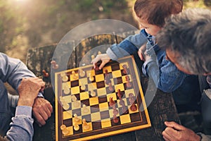 Two senior men having fun and playing chess at park