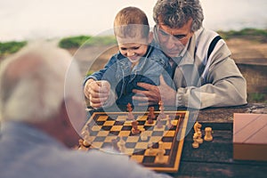 Two senior men having fun and playing chess at park