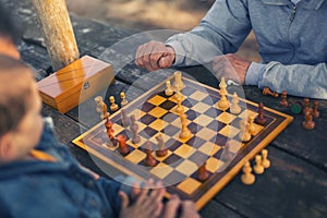 Two senior men having fun and playing chess at park