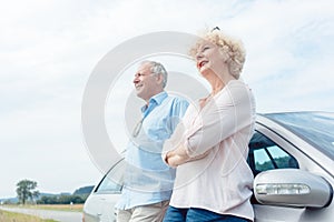 Two senior people smiling with confidence while leaning on their