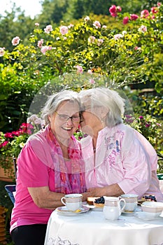 Two senior women chatting in garden