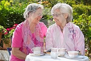 Two senior women chatting at table