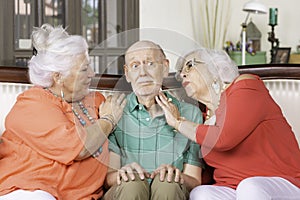 Two Senior Women Lavishing Affection on a Single Man photo