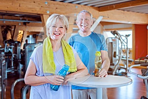 Two seniors having a break from exercising in the gym