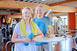 Two seniors having a break from exercising in the gym