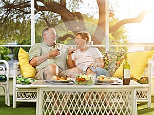 Two seniors having dinner on patio.