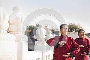 Two seniors practicing Taijiquan in Beijing, arms in a circle