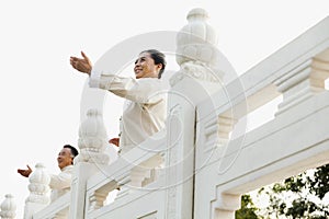 Two seniors practicing Taijiquan in Beijing, arms in front