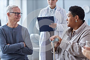 Two seniors sharing stories sitting in circle at mental health support group