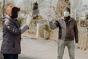 Two seniors wearing facial masks and gloves waves by the appointment