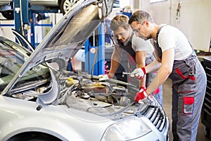 Two servicemen in a car workshop