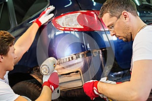 Two servicemen in a car workshop