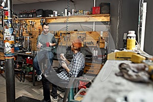 Two servicemen having lunch in bicycle workshop