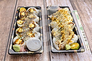 Two sets of delicious maki in disposable plastic trays. Made for takeout or for Japanese fast food dine-in