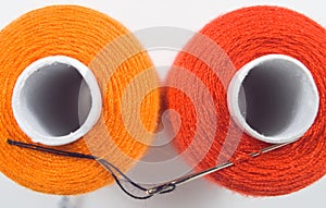 two sewing spools with a needle