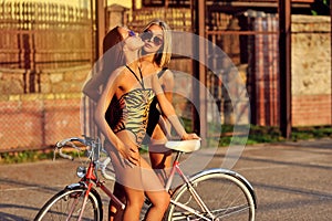 Two women in swimsuits with vintage bike photo