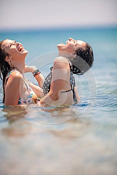 Two Young Girls having fun at the beach inside the sea