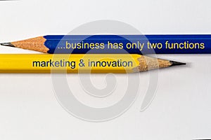 Two sharpened pencils in blue and yellow point in different directions isolated against a white background with the busines wisdom
