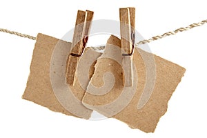 Two sheets of craft paper attached to a rope with clothespins isolated on white background