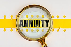 Between two sheets from a notebook on a yellow strip with the inscription - ANNUITY, there is a magnifying glass.